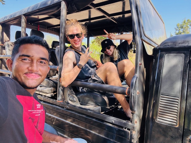 Group in a safari jeep giving peace signs