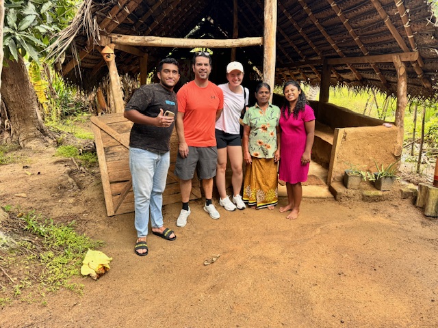 Travellers with a local family at a traditional village home